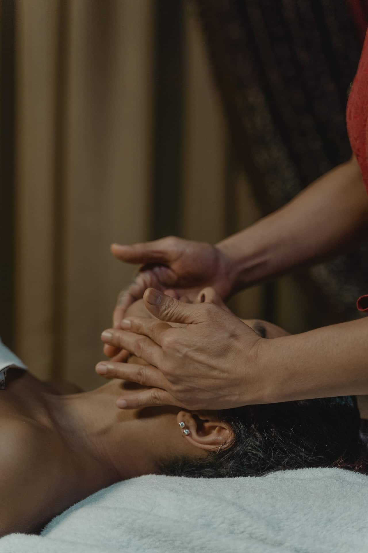 Therapist preparing essential oils and towels for an Indian spa session