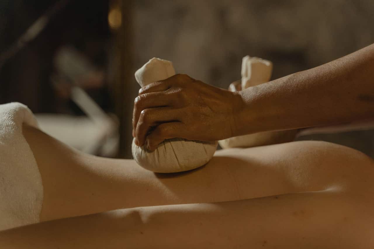 Indian spa wellness setup with stones, oils, and rolled towels near Tadepalli
